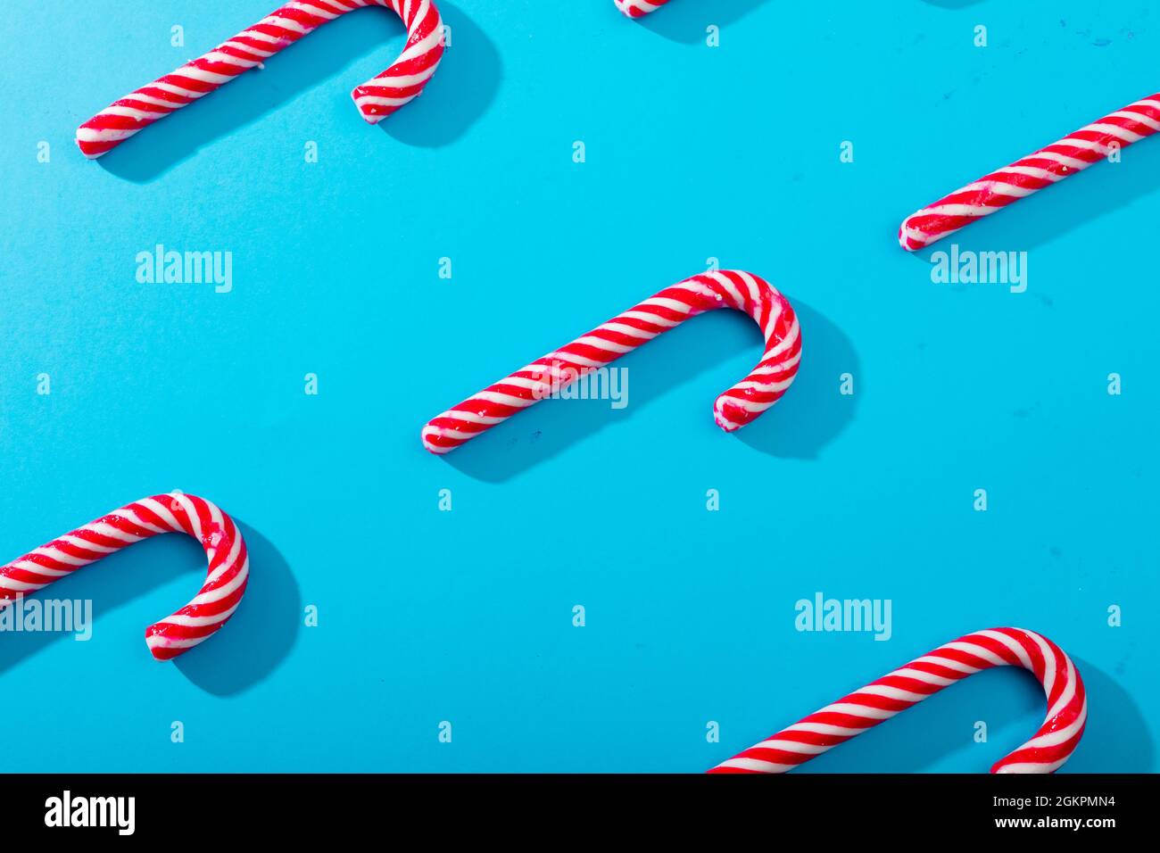 Composition of multiple rows of candy canes on blue background Stock Photo
