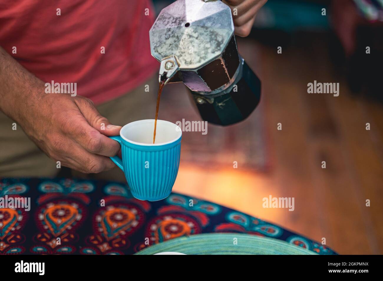 Man pouring coffee from a coffee maker into a cup Stock Photo
