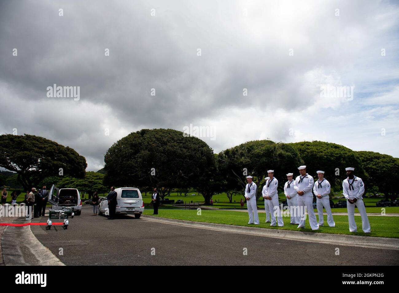 Members of the U.S. Navy Region Hawaii Honor Guard lift participate in a funeral for the Trapp brothers at the National Memorial Cemetery of the Pacific, Honolulu, Hawaii, June 15, 2021. The Trapp brothers were assigned to the USS Oklahoma, which sustained fire from Japanese aircraft and multiple torpedo hits causing the ship to capsize and resulted in the deaths of more than 400 crew members on Dec. 7, 1941, at Ford Island, Pearl Harbor. The Trapp brothers were recently identified through DNA analysis by the Defense POW/MIA Accounting Agency (DPAA) forensic laboratory and laid to rest with fu Stock Photo