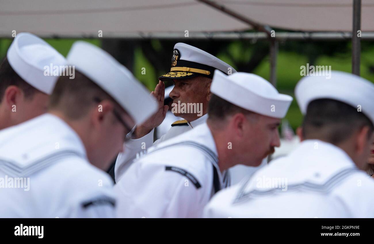 U.S. Navy Rear Adm. Darius Banaji, deputy director for operations for the Defense POW/MIA Accounting Agency (DPAA), salutes during a funeral for the Trapp brothers at the National Memorial Cemetery of the Pacific, Honolulu, Hawaii, June 15, 2021. The Trapp brothers were assigned to the USS Oklahoma, which sustained fire from Japanese aircraft and multiple torpedo hits causing the ship to capsize and resulted in the deaths of more than 400 crew members on Dec. 7, 1941, at Ford Island, Pearl Harbor. The Trapp brothers were recently identified through DNA analysis by the DPAA forensic laboratory Stock Photo
