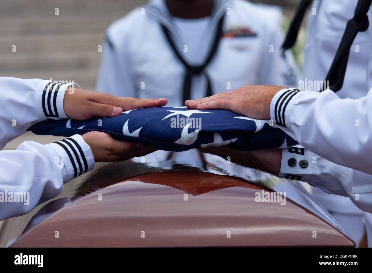 Members of the U.S. Navy Region Hawaii Honor Guard fold an American flag during a funeral for the Trapp brothers at the National Memorial Cemetery of the Pacific, Honolulu, Hawaii, June 15, 2021. The Trapp brothers were assigned to the USS Oklahoma, which sustained fire from Japanese aircraft and multiple torpedo hits causing the ship to capsize and resulted in the deaths of more than 400 crew members on Dec. 7, 1941, at Ford Island, Pearl Harbor. The Trapp brothers were recently identified through DNA analysis by the Defense POW/MIA Accounting Agency (DPAA) forensic laboratory and laid to res Stock Photo