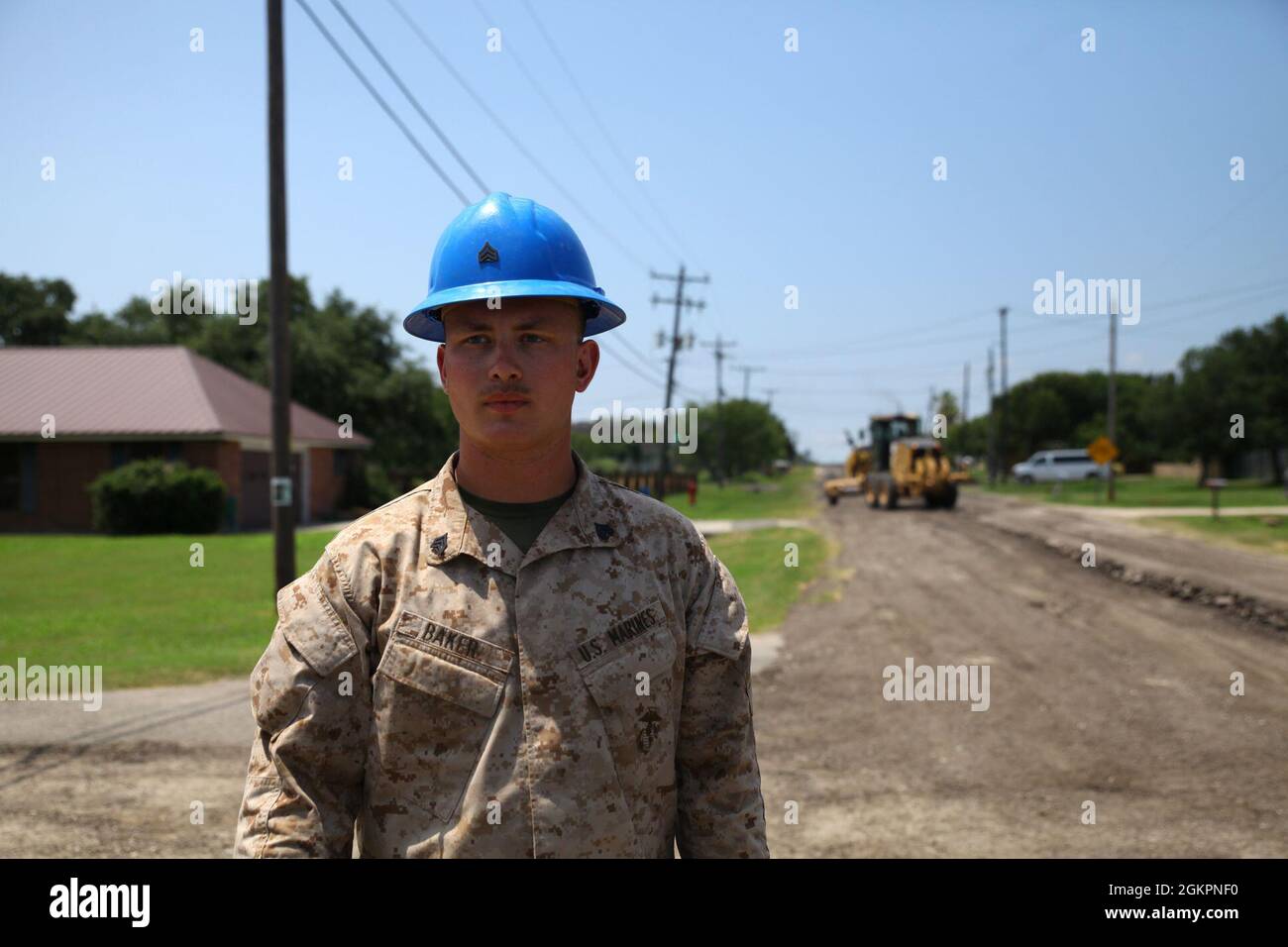 Sgt. Adam Baker, team leader with Marine Wing Support Squadron (MWSS) 272, supervises the final grading of County Road 73A on June 15th, 2021 in Corpus Christi, Texas. Marines are lending their assistance to Neuces County as part of Colonias 21, a project from the Innovative Readiness Training program which matched the heavy equipment training needs of MWSS 272 with the flood mitigation needs of the local community. Stock Photo