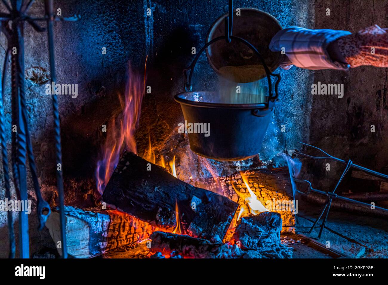 In Cerentino, visitors can stay in the lavishly renovated historic patrician house Cà Vegia, with centuries-old original furnishings but without electricity. Polenta is prepared over the open fire, Circolo della Rovana, Switzerland Stock Photo