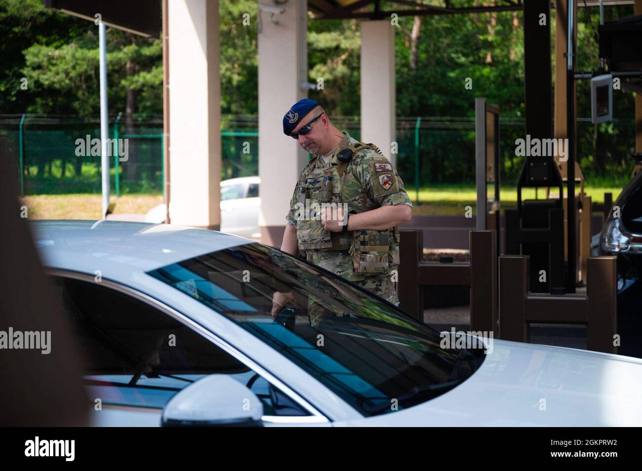 A patrolman assigned to the 86th Security Forces Squadron conducts a security check of vehicles entering Ramstein Air Base, Germany, June 15, 2021. Members assigned to the 86 SFS keep Ramstein entry and exit points secure while ensuring every person has correct identification. Stock Photo
