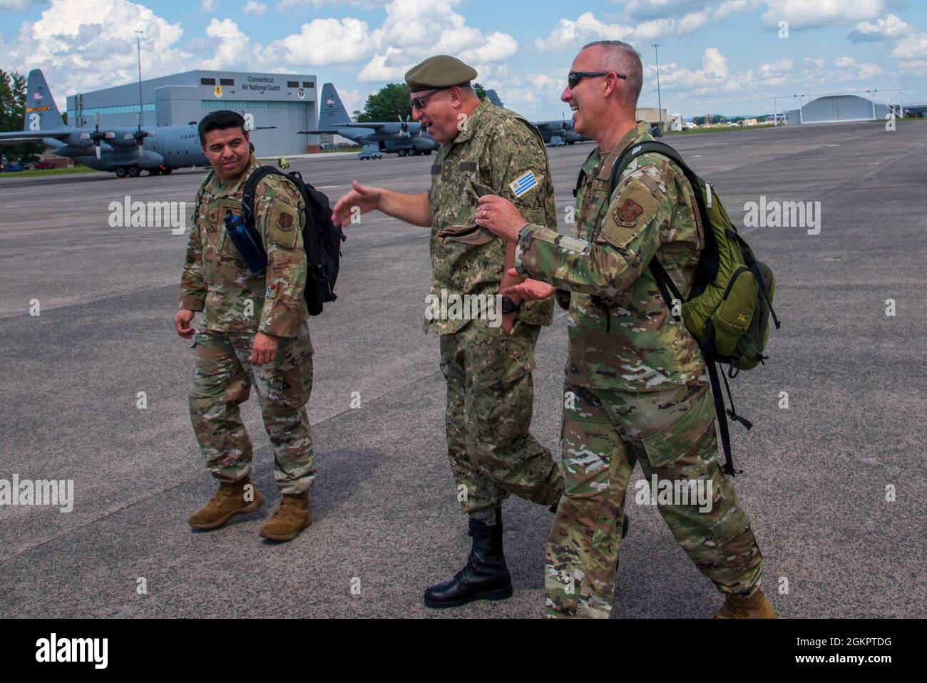 Uruguayan Army Maj. Gen. Hugo Rebollo, U.S. Air Force Col. Tom Olander and  U.S. Air Force Maj. Jaime Zambrano discuss tactical airlift operations at  the 103rd Airlift Wing in Windsor Locks, Conn.
