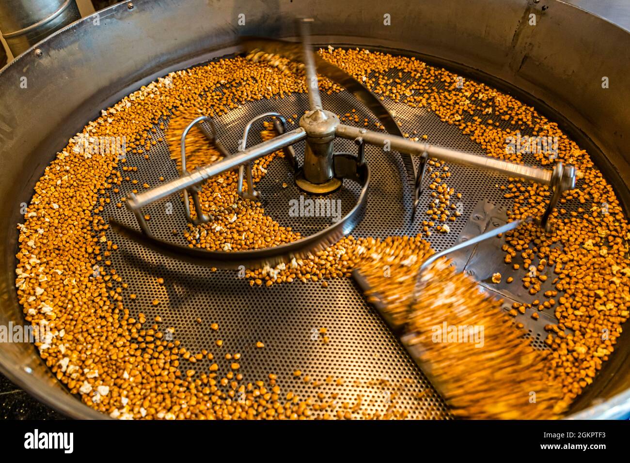 The roasted corn kernels cool as they are constantly moved. Circolo d'Onsernone, Switzerland Stock Photo