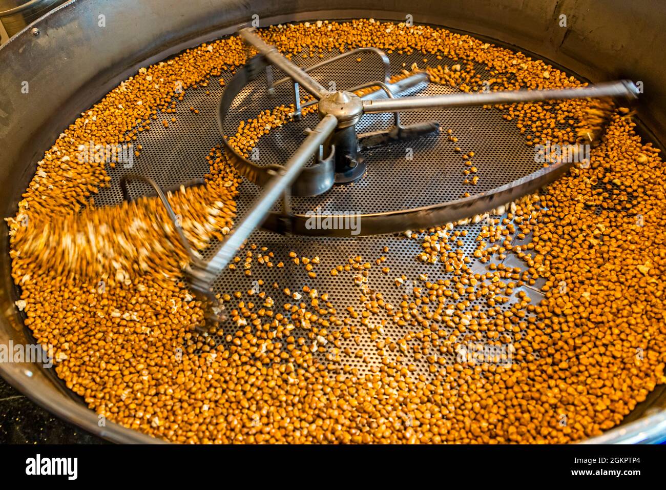 The roasted corn kernels cool as they are constantly moved. Circolo d'Onsernone, Switzerland Stock Photo