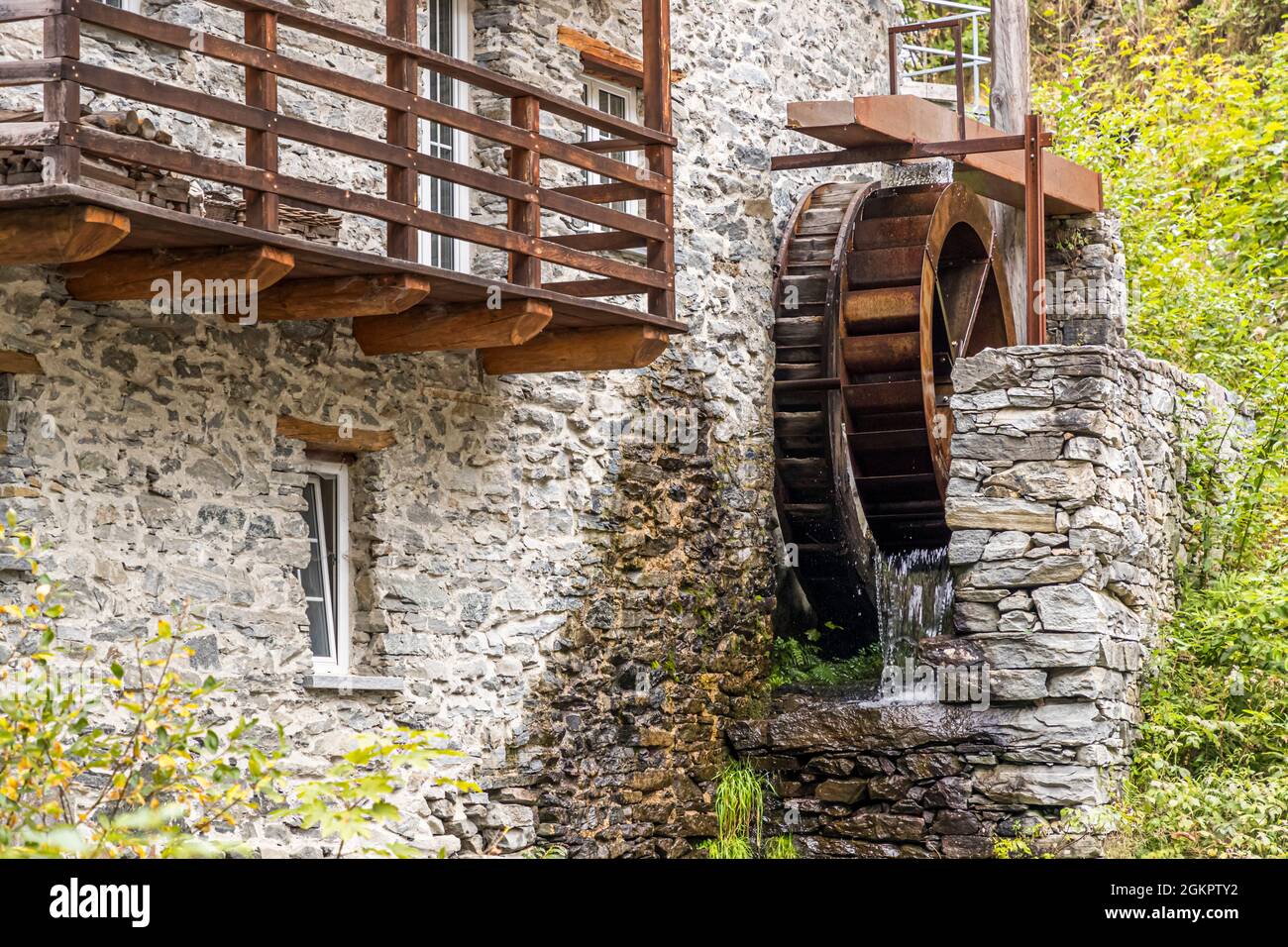 While outside the mill wheel is driven by water power, inside the mill an ancient mechanism still ensures the perfect fineness of Farina Bona in Circolo d'Onsernone, Switzerland Stock Photo