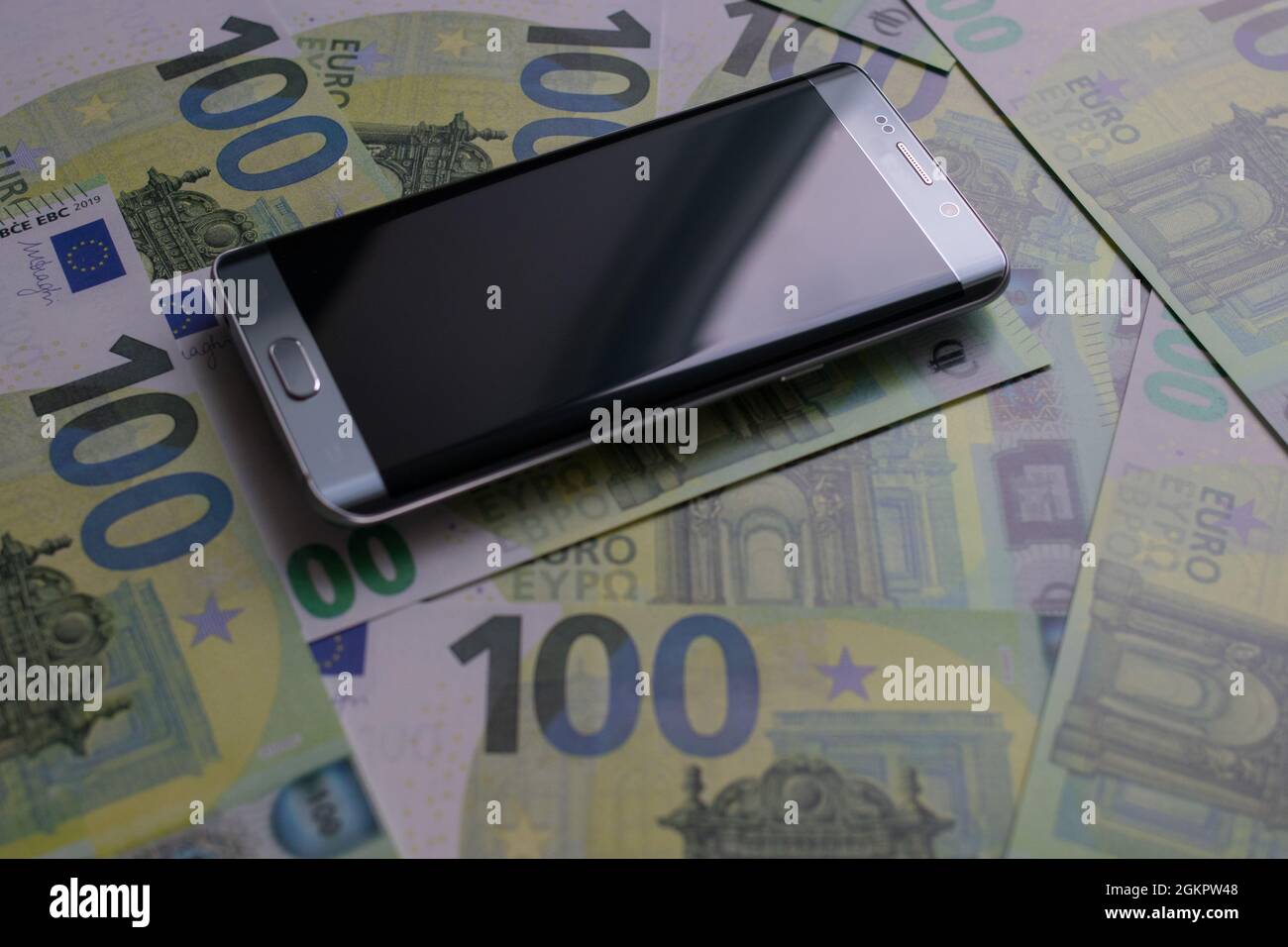 smartphone lies on 100 euro banknotes Stock Photo