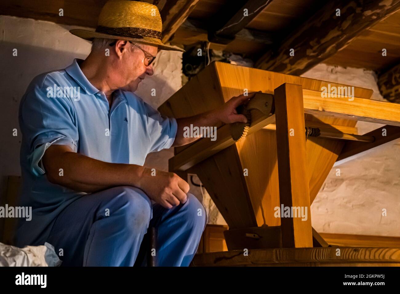 The man with the straw hat. For many years Ilario Galbani has been tinkering with the resurrection of Farina Bona. While outside the mill wheel is driven by water power, inside the mill an ancient mechanism still ensures the perfect fineness of Farina Bona in Circolo d'Onsernone, Switzerland Stock Photo