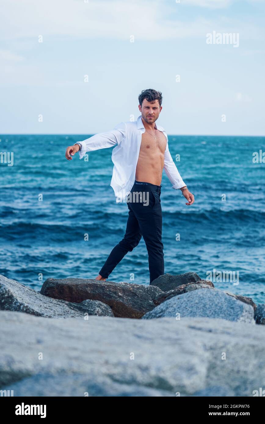 Handsome caucasian male in sportswear poses on the beach wearing a mask  Stock Photo - Alamy
