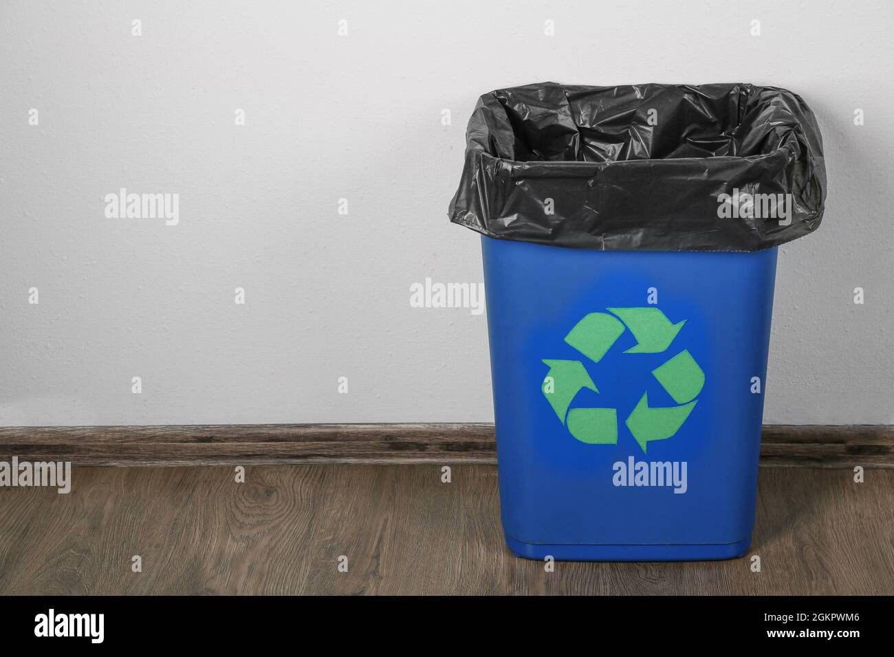 Blue rubbish bin with logo of recycling in room Stock Photo Alamy