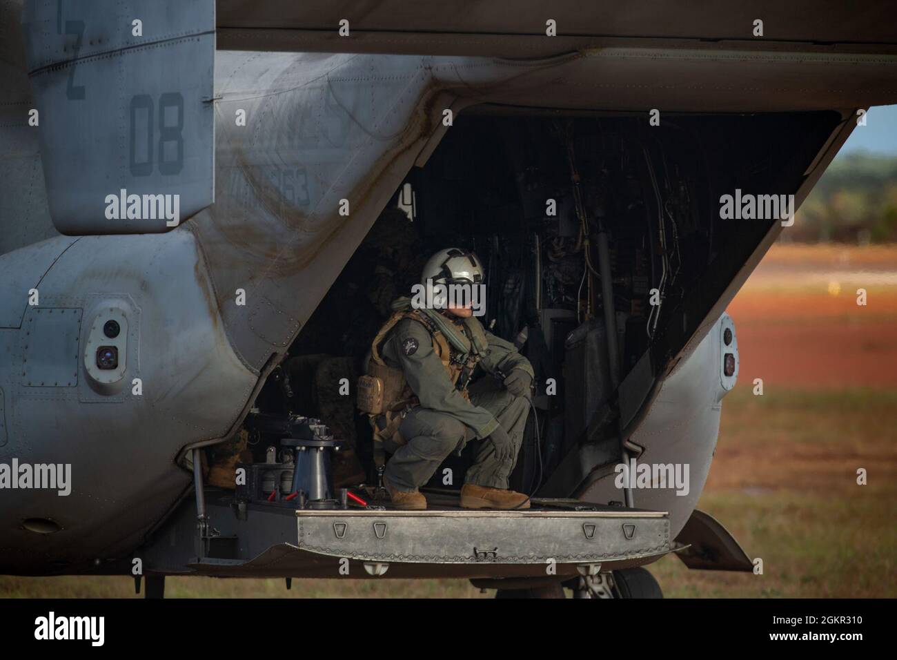 A U.S. Marine with Marine Medium Tiltrotor Squadron - 363 with Marine Rotational Force - Darwin, squats in an MV-22B Osprey after landing at Gove Airport in Nhulunbuy, NT, Australia, June 17, 2021. Marines redeployed from Nhulunbuy to Darwin on MV-22B Ospreys after the successful completion of Exercise Darrandarra. Darrandarra, meaning “together,” demonstrates the Marines Corps’ ability to operate with the Australian Defence Force and reinforce embassies and conduct noncombatant evacuation operations in response to crises and contingencies in the Indo-Pacific region. Stock Photo