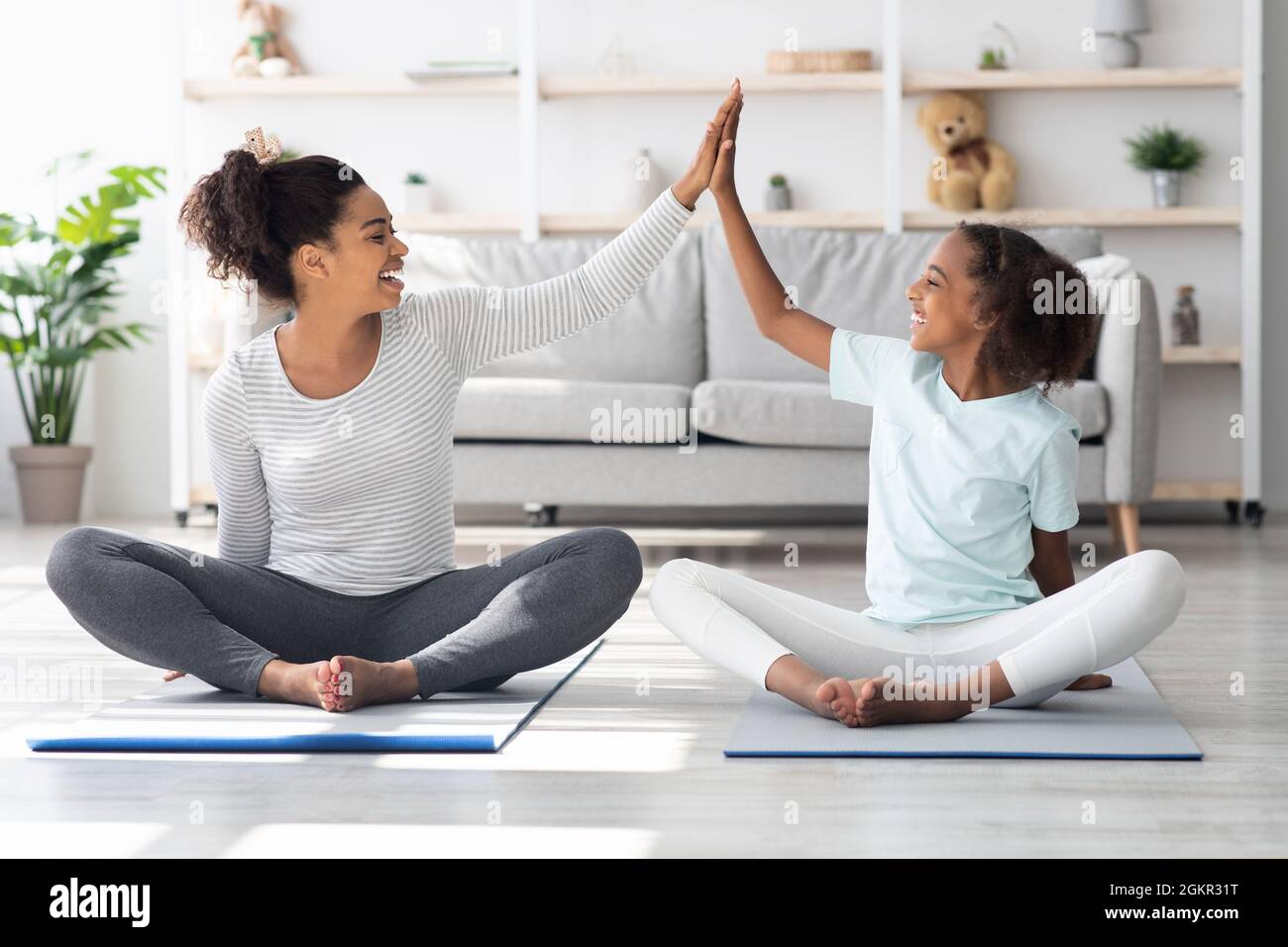 Sporty black family mother and daughter exercising at home Stock Photo ...