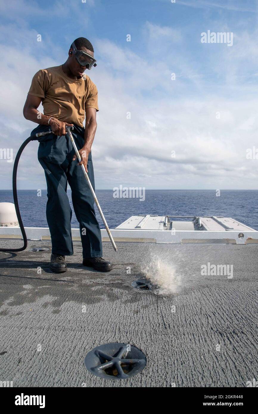 Aviation Boatswain's Mate (Handling) Airman Zion Porter, from Chesterfield, Virginia, assigned to USS Gerald R. Ford’s (CVN 78) air department, preforms a blowdown rotation on Ford’s flight deck, June 17, 2021. Ford is underway in the Atlantic Ocean conducting Full Ship Shock Trials (FSST). The U.S. Navy conducts shock trials of new ship designs using live explosives to confirm that our warships can continue to meet demanding mission requirements under the harsh conditions they might encounter in battle. Stock Photo