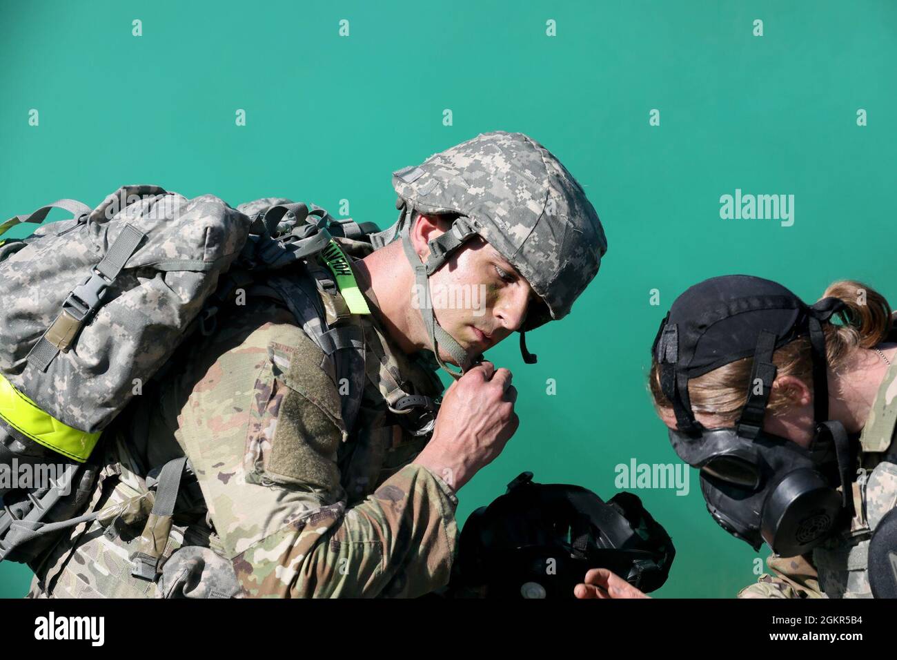 Spc. Colin Hoffmann, left, unsnaps his helmet as Capt. Laura Benz gets ready to assist, during a simulated gas attack, Regional Health Command-Pacific Best Leader Competition, Joint Base Lewis-McChord, Wash., June 17, 2021. Both are assigned to U.S> Army Medical Department Activity-Alaska. The Best Leader Competition promotes esprit de corps across the Army, while recognizing Soldiers who demonstrate the Army Values and embody the Warrior Ethos. The competition recognizes those Soldiers who possess superb military bearing and communication skills, in-depth knowledge of military subjects, and t Stock Photo
