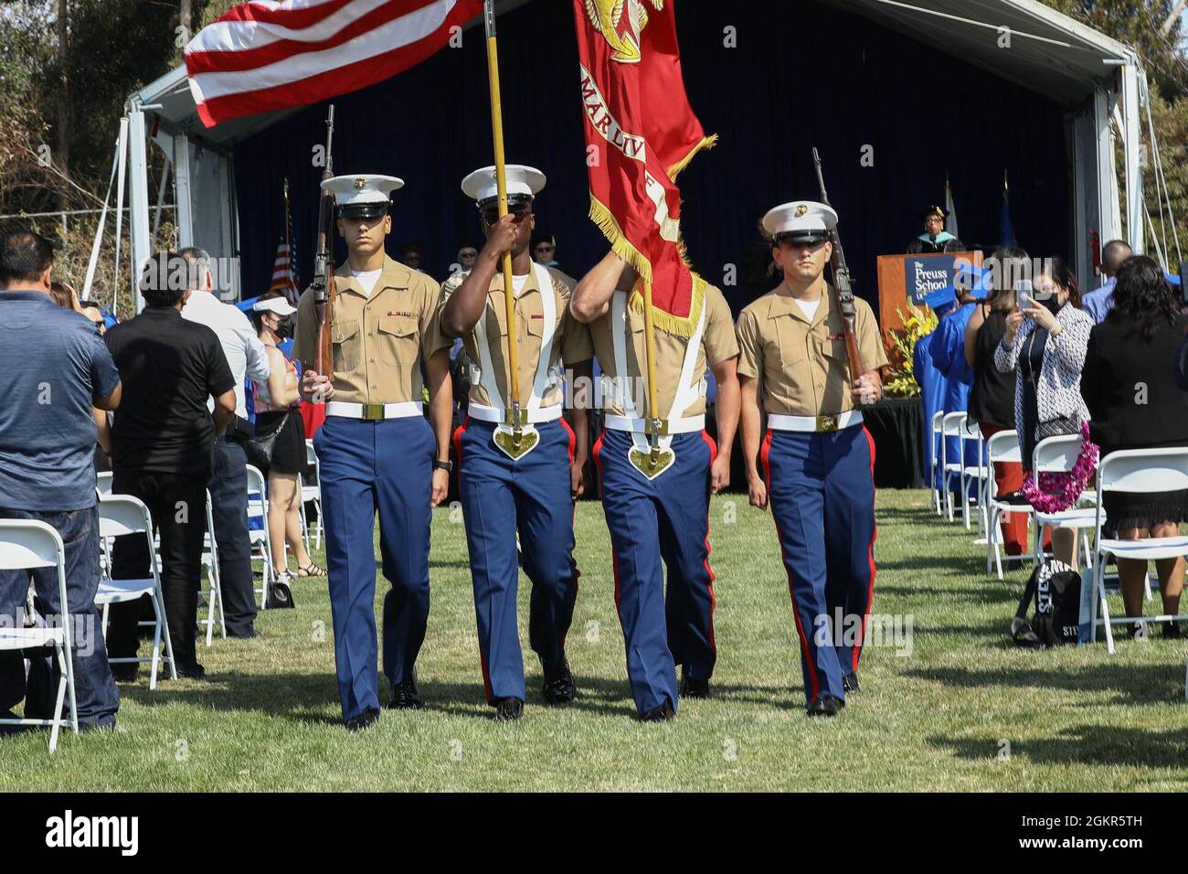 The 1st Marine Division (1st MARDIV) color guard marches the national colors and Marine Corps colors during a graduation ceremony at The Preuss School University of California San Diego in San Diego, California, June 17, 2021. The 1st MARDIV color guard attended the graduation to reinforce relationships with the local community. Stock Photo