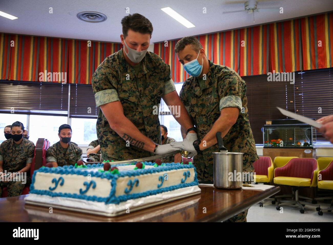 U.S. Navy Hospitalman 2nd Class Jassen Bauer and Hospitalman George Grant  with Division Surgeon's Office, 3d Marine Division, participate in a  cake-cutting ceremony in celebration of the 123rd U.S. Navy Corpsmen  Birthday