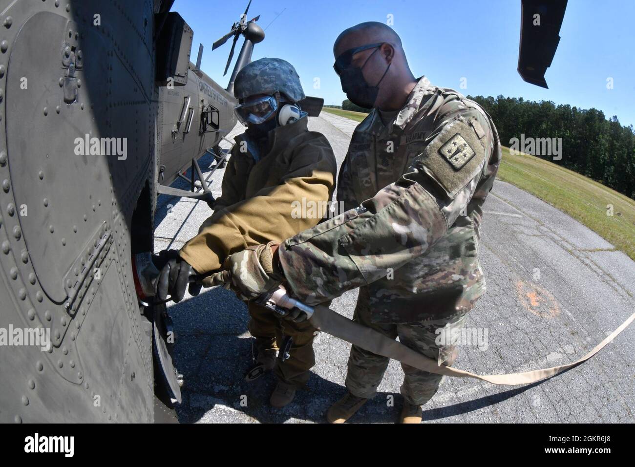 Staff Sgt. Bernard Hudgison helps Pvt. Jaelyn Belew from Uniform