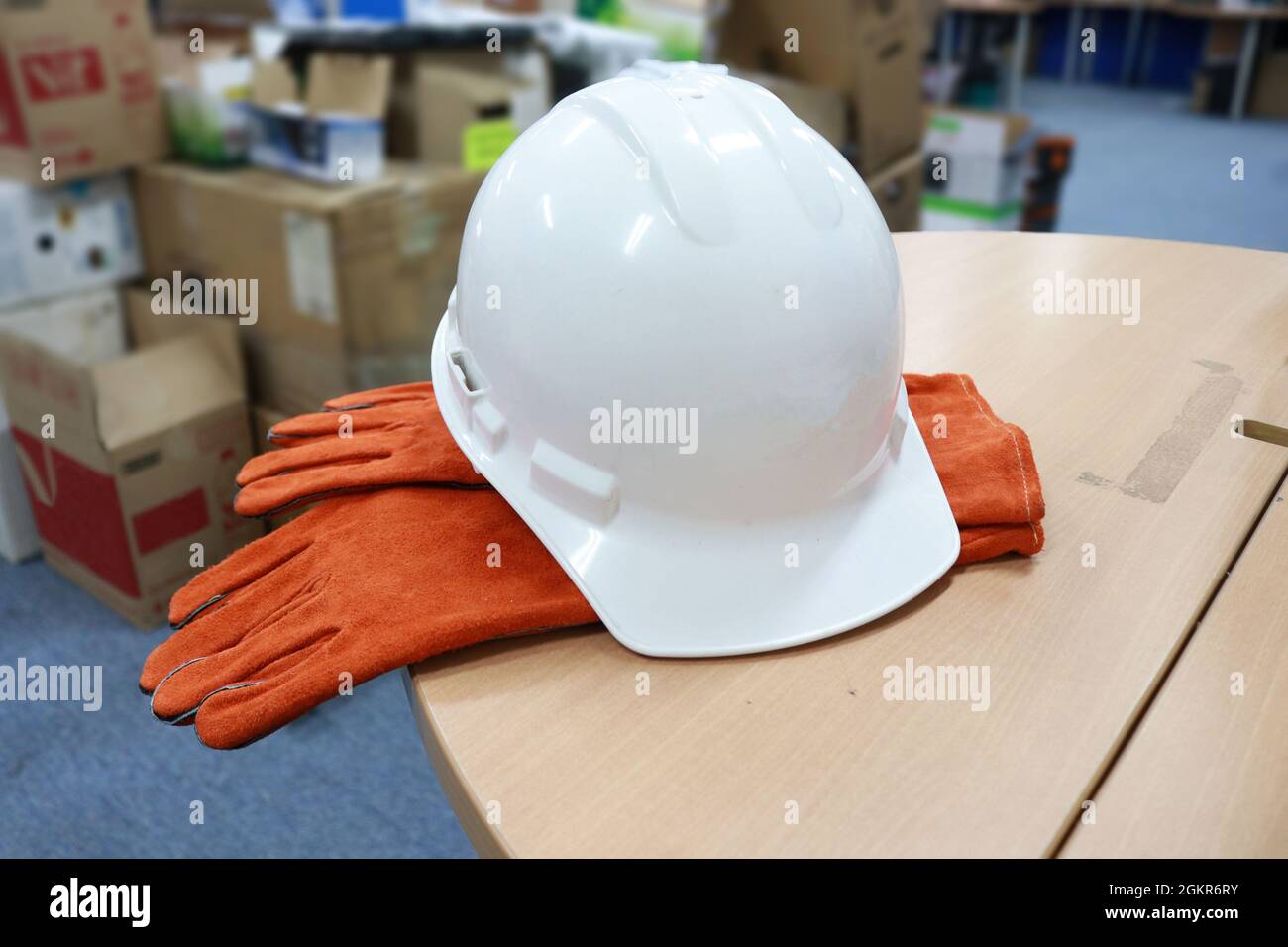 White safety helmet to protect workers' heads from work accidents, such as collisions with hard objects, leather gloves to protect hands, Stock Photo