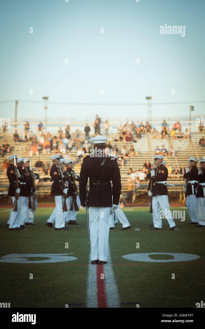 U.S. Marine Corps Capt. Isaac Seals, platoon commander of the Marine Corps Silent Drill Platoon, observes his Marines as they perform their signature routine during the 8th Annual Basilone Bowl at Bridgewater-Raritan Regional High School, in  Bridgewater, New Jersey, June 16, 2021. The Basilone Bowl is an All-Star football game played in honor of legendary Medal of Honor recipient, U.S. Marine Corps Gunnery Sgt. John Basilone, who grew up in nearby Raritan, New Jersey. Stock Photo