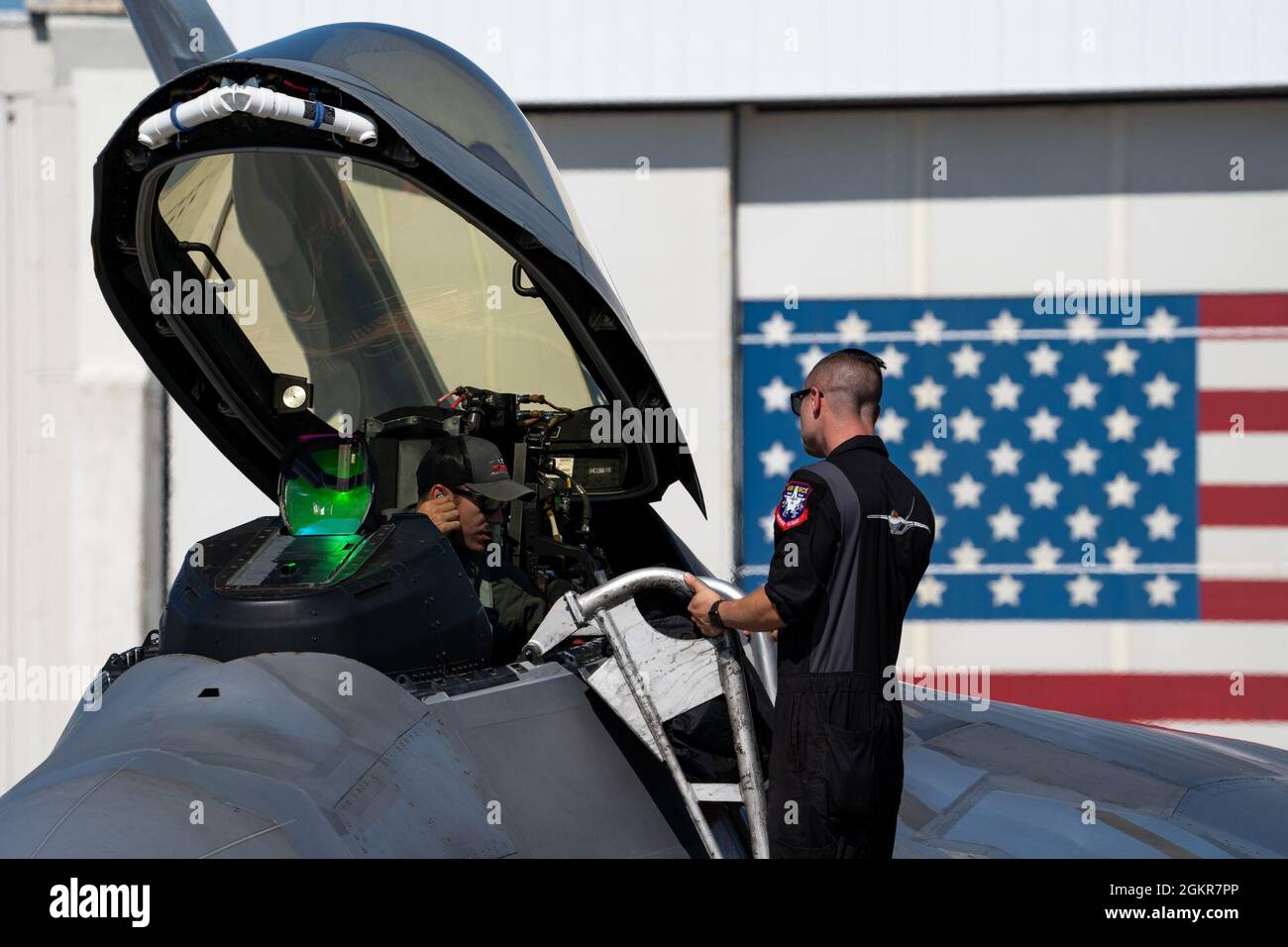 U.S. Air Force Maj. Josh Gunderson, F-22 Demo Team commander, speaks with Tech. Sgt. Lenny Buscemi, F-22 Demo Team crew chief, upon arrival at Wallops Island Flight Facility NASA hanger June 17, 2021, at Wallops Island, Va. Crew chiefs like Buscemi are responsible for all the mechanical maintenance of the aircraft, and ensure the F-22 Raptor demonstration is conducted on time during an airshow. Stock Photo