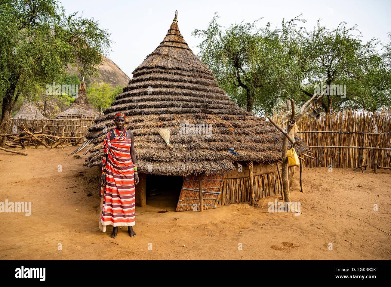 Young women in front of a traditional village hut of the Laarim tribe, Boya Hills, Eastern Equatoria, South Sudan, Africa Stock Photo
