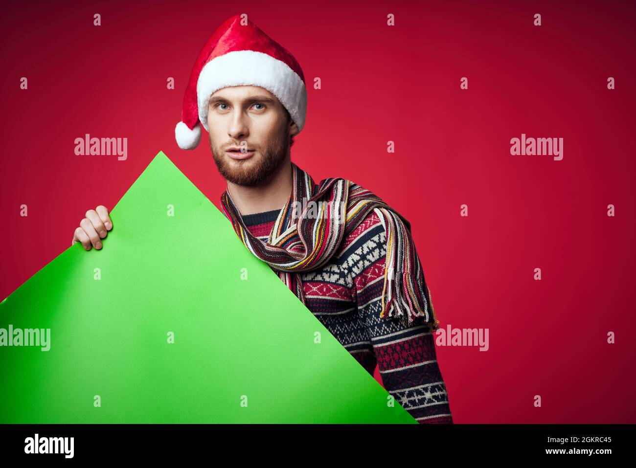 handsome man in a santa hat holding a banner holiday red background ...