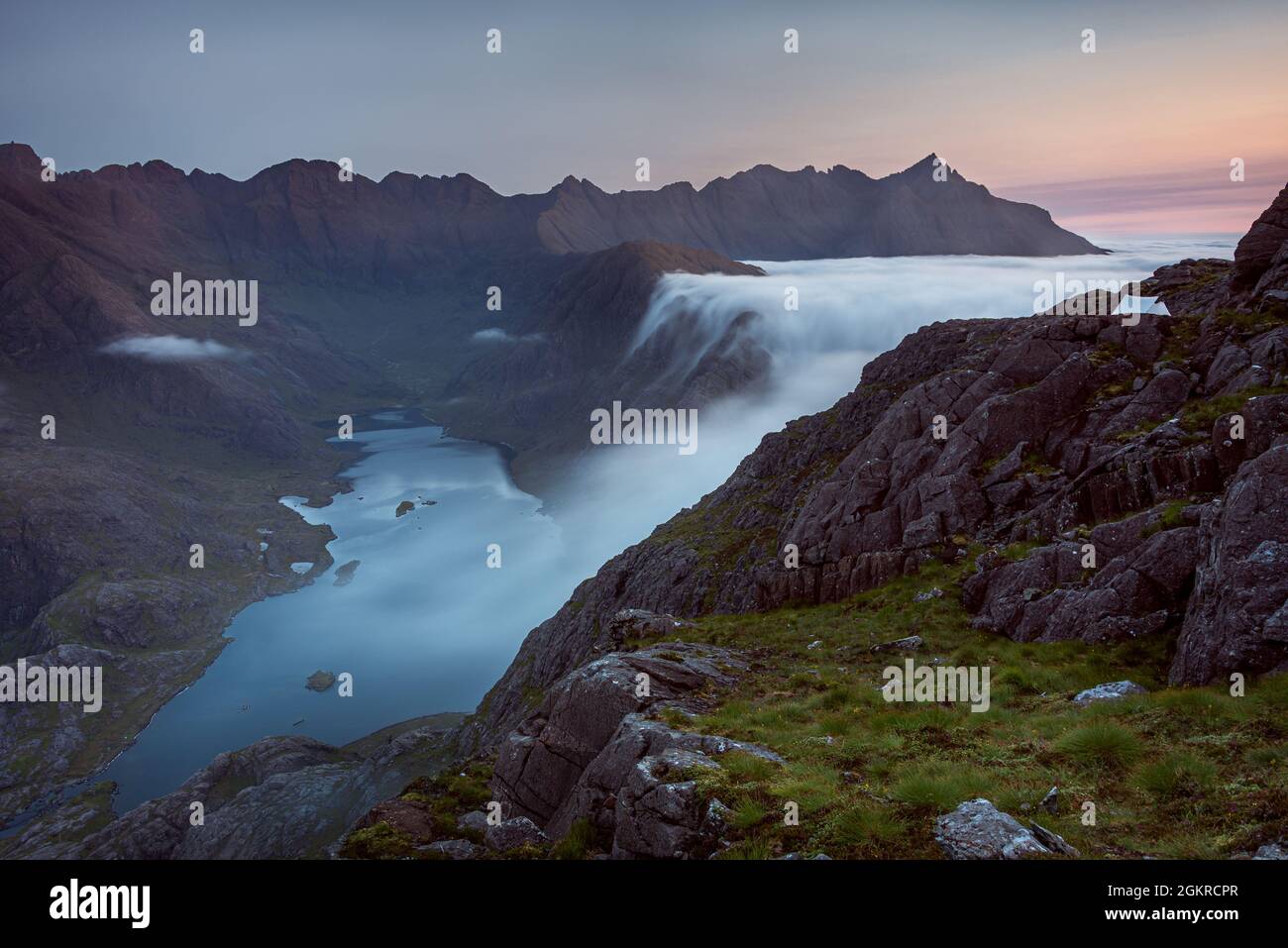 Sunrise at a wild camp on the hills above Loch Coruisk on Skye with a cloud inversion flooding into the glen below, Isle of Skye, Scotland Stock Photo