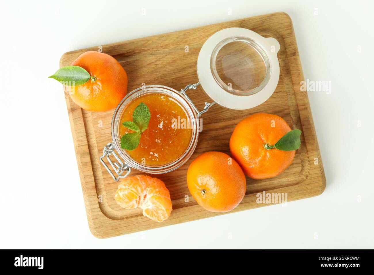 Board with mandarin jam and ingredients on white background Stock Photo