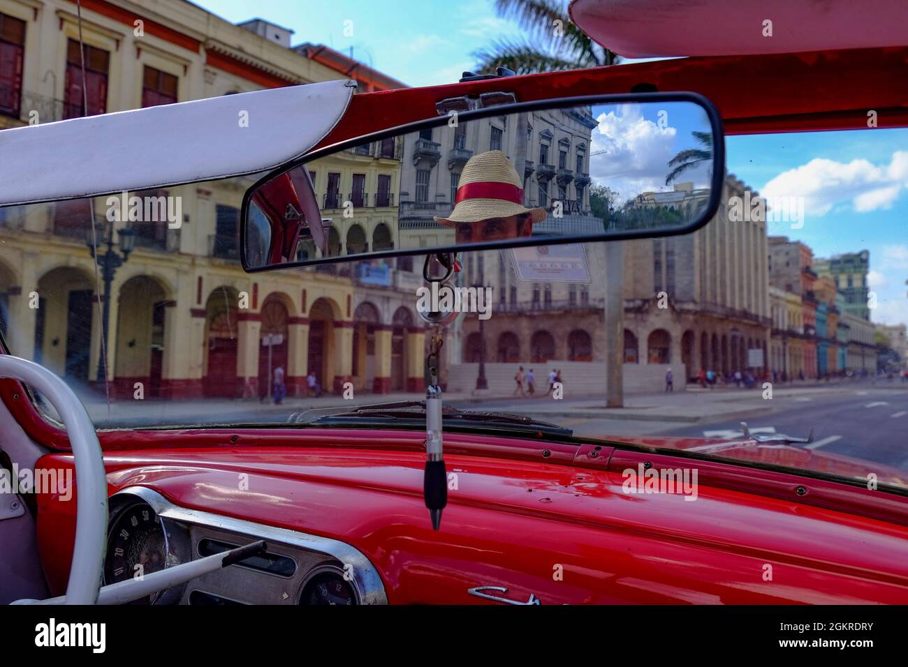 Taxi driver in straw hat seen in rear-view mirror of vintage car, Havana, Cuba, West Indies, Central America Stock Photo