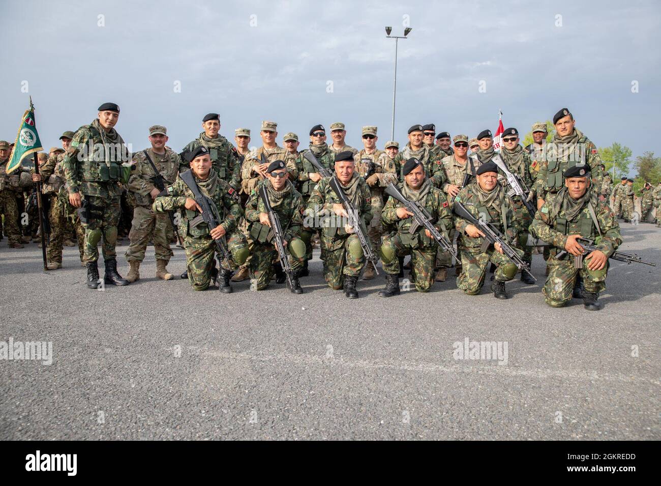 Albanian and American service members pause for a photo at the Joint Readiness Training Center, Camp Albershof, Hohenfels, Germany, June 20, 2021. All have just participated in a first formation between American and select, international counterparts soon to serve as the Kosovo Force 29 Maneuver Battalion. Stock Photo