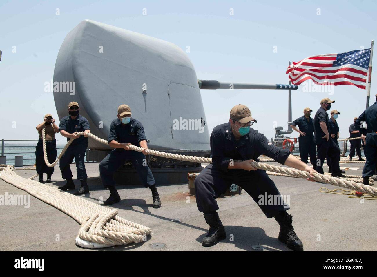 210620-N-WQ732-1065 NAVAL SUPPORT ACTIVITY, Bahrain (June 20, 2021) – Fire Controlman (Aegis) 3rd Class Patricia King, left, Fire Controlman (Aegis) Seaman Sean Junkins, center, and Fire Controlman (Aegis) 3rd Class Daniel Barry hold mooring lines as guided-missile cruiser USS Monterey (CG 61) arrives in Naval Support Activity Bahrain, June 20. Monterey is operating with the Eisenhower Carrier Strike Group while deployed to the U.S. 5th Fleet area of operations in support of naval operations and providing airpower to protect U.S. and coalition forces as they conduct drawdown operation from Afg Stock Photo