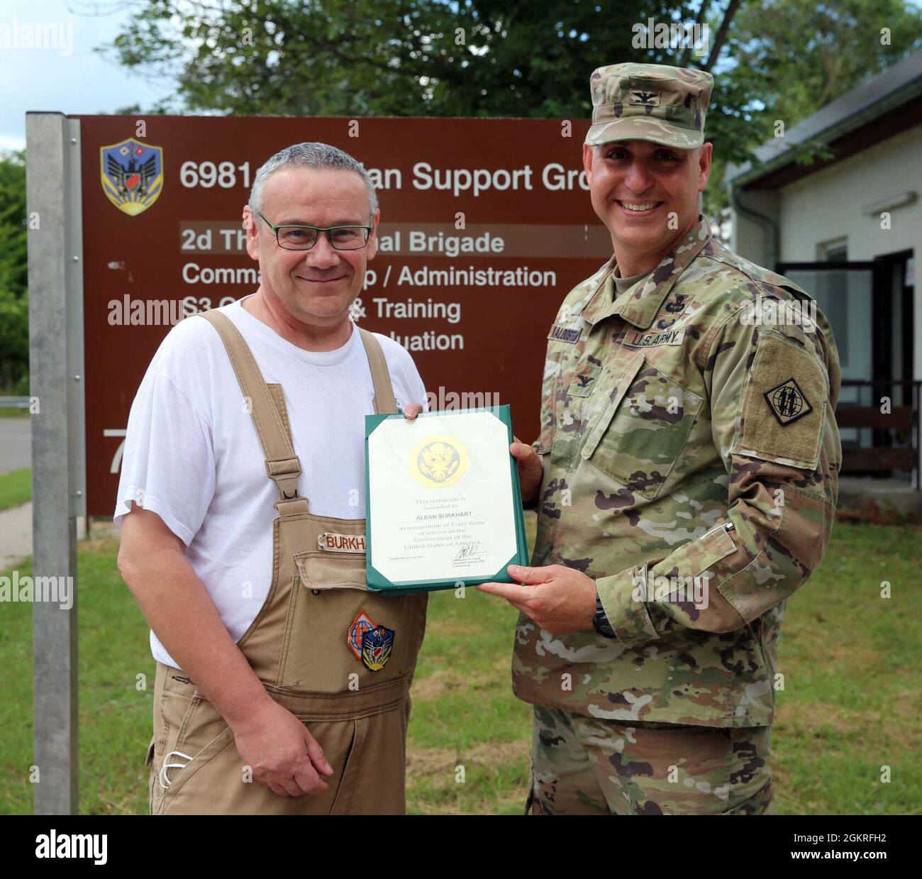 GERMERSHEIM, Germany -- Col. Michael Kaloostian, Commander, 2d Theater Signal Brigade, presents a Certificate of Appreciation to Mr. Alban Burkhart, 6981st Civilian Support Group, June 21, 2021 in recognition of Mr. Burkhart’s 40 years of service in the Government of the United States of America. Stock Photo