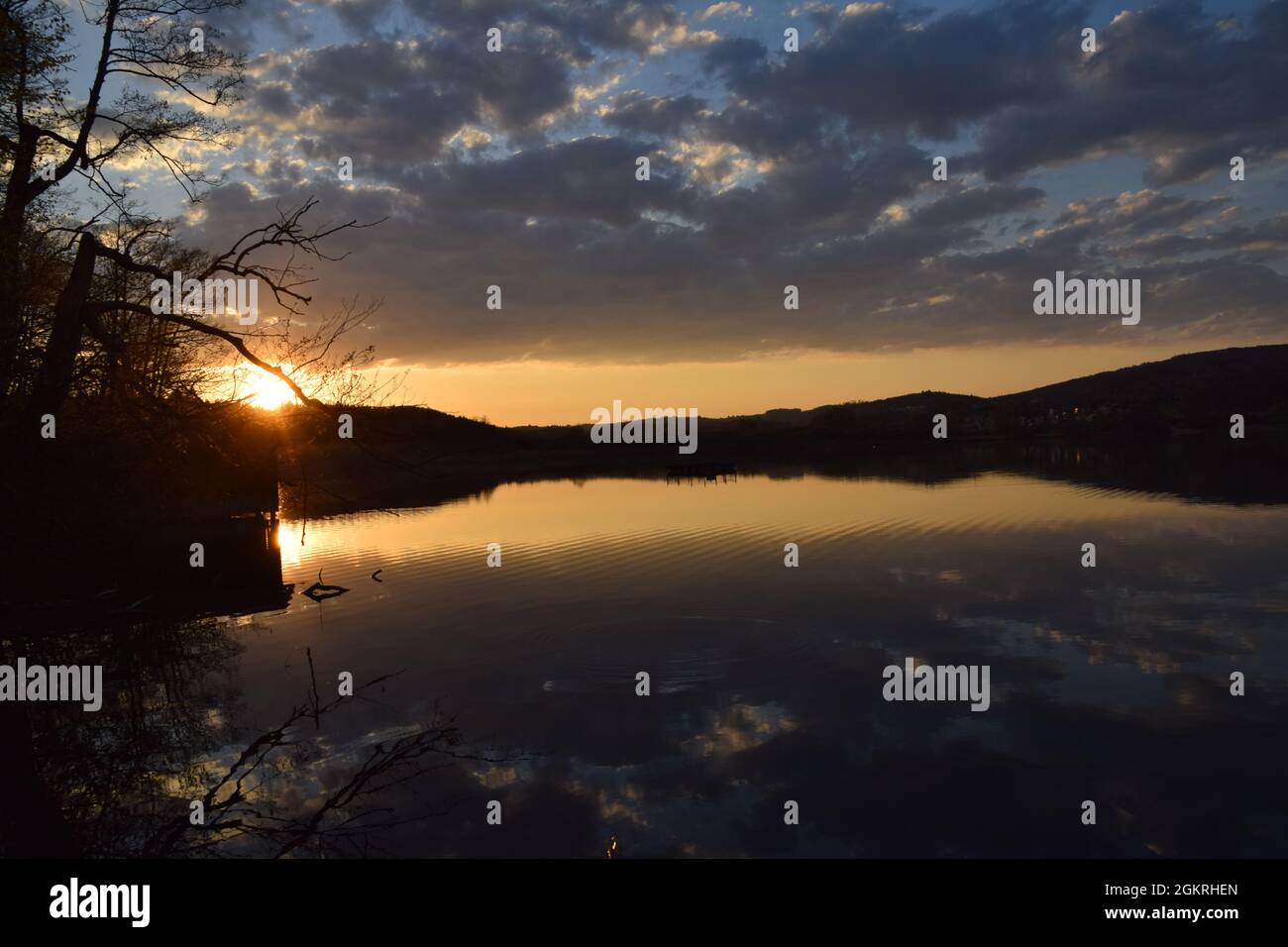 Sonnenuntergang mit wolken und einem baum im wasser gespiegelt am mindelsee bei radolfzell bodensee lake of constance fotografiert mit der nikond3300 Stock Photo