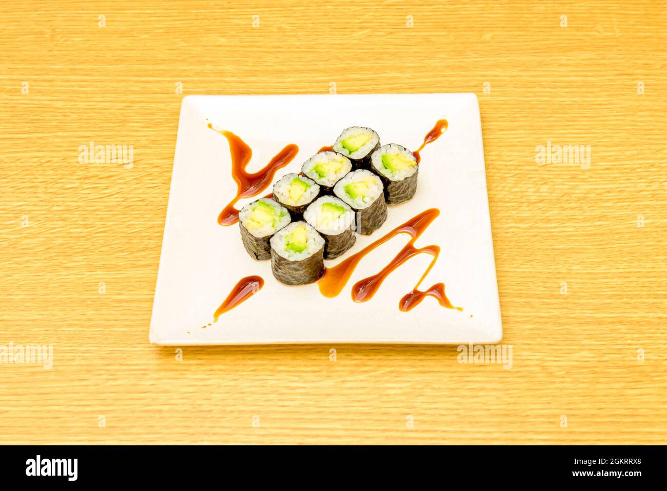 Ocho piezas de sushi maki de aguacate maduro con arroz japones, algas nori y salsa de soja Stock Photo