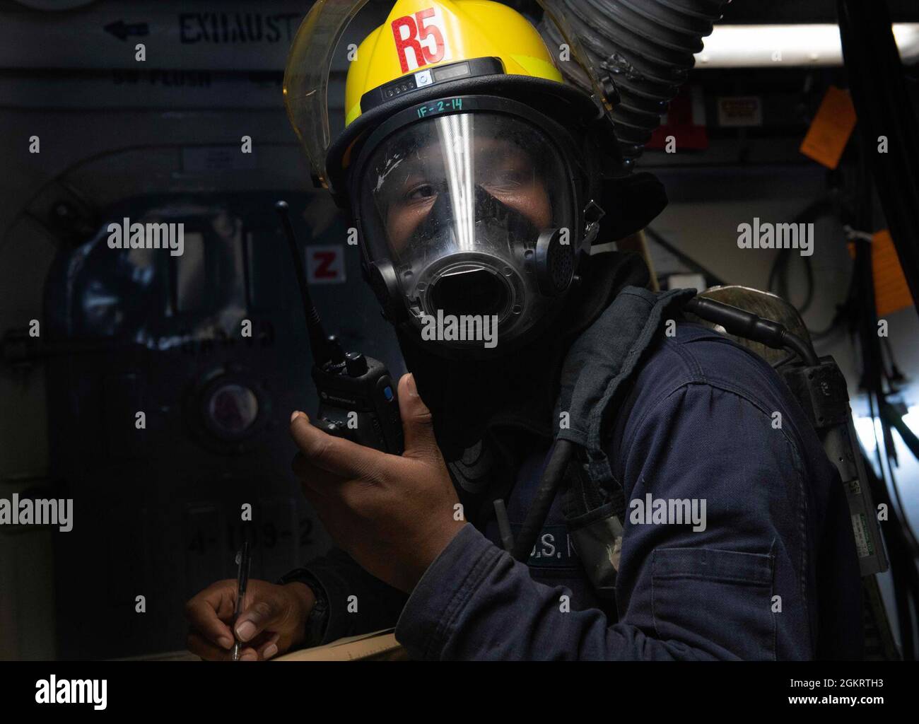 YOKOSUKA, Japan (June 23, 2021) – Hull Maintenance Technician 2nd Class  Tony Skipper, from Jacksonville, Fla., relays information over the  hand-held radio as the on-scene leader during an integrated fire drill with