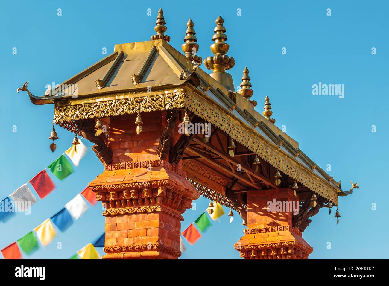 Nepalese ornamental entrance gate of a temple with colorful flags Stock Photo