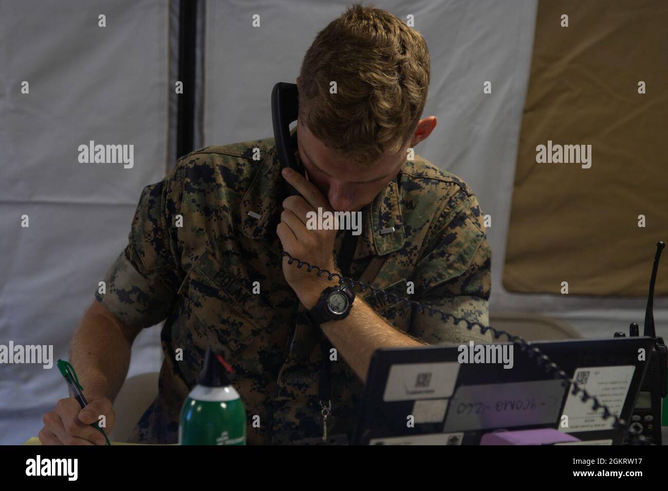 U.S Marine Corps 1st Lt. Frederick Polak, a systems command (SYSCOM) watch officer with 9th Communications Battalion (9th Comm), I Marine Expeditionary Force Information Group (I MIG) calls other units for status reports at Marine Corps Base Camp Pendleton, California, June 23, 2021. SYSCOM assists I MIG by maintaining the health of I MIG’s network, allowing I MIG to keep constant communications in the information environment. Stock Photo