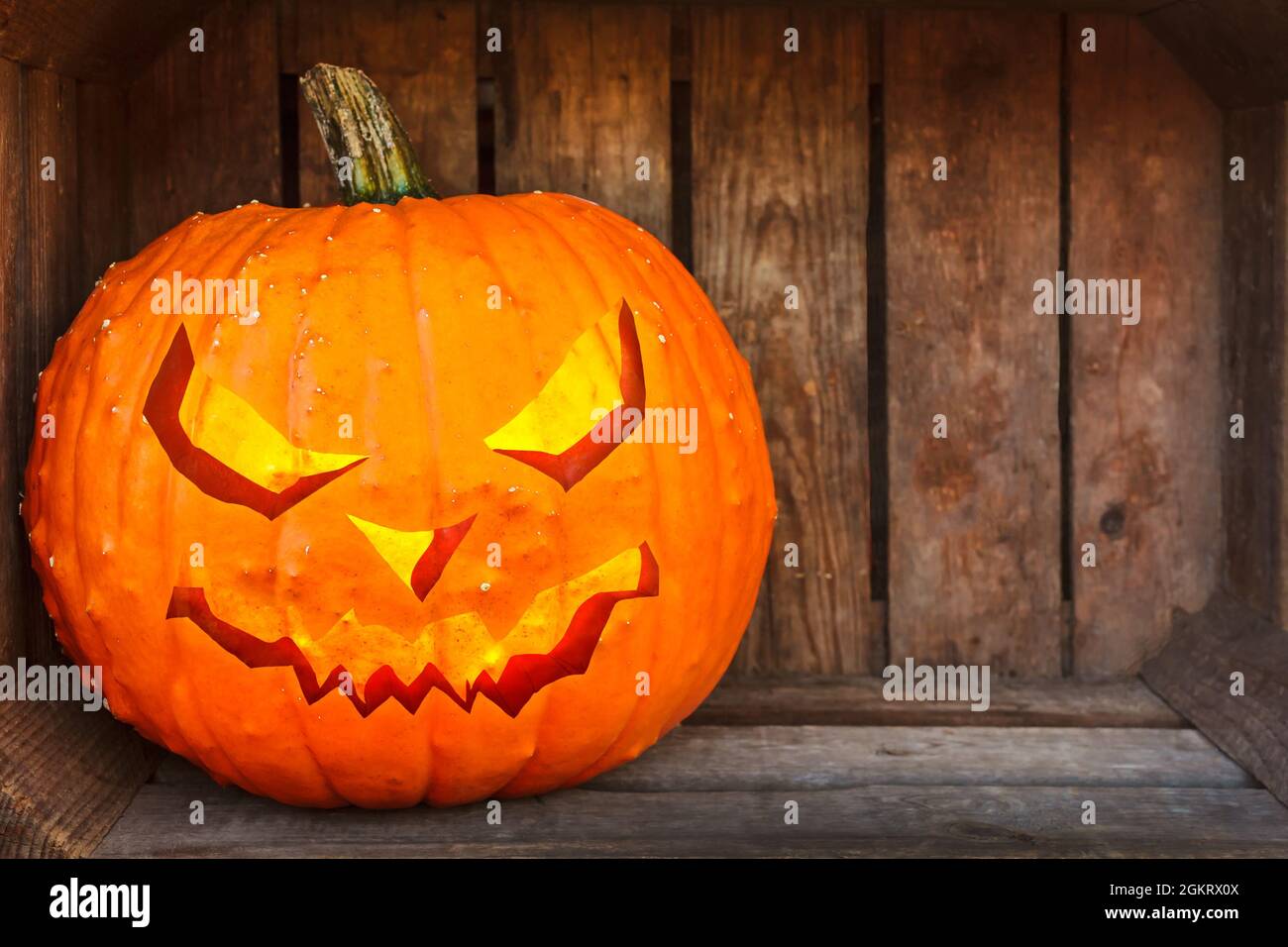 Halloween pumpkin lantern inside an old wooden crate with room for copy space Stock Photo