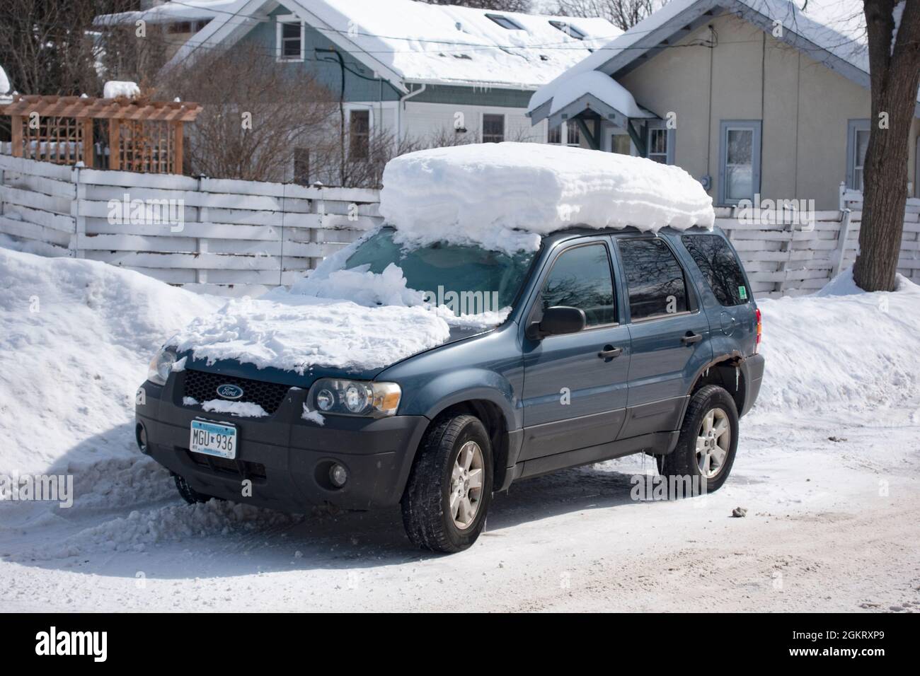 Car on the street showing a foot of snow on top of the roof. St Paul
