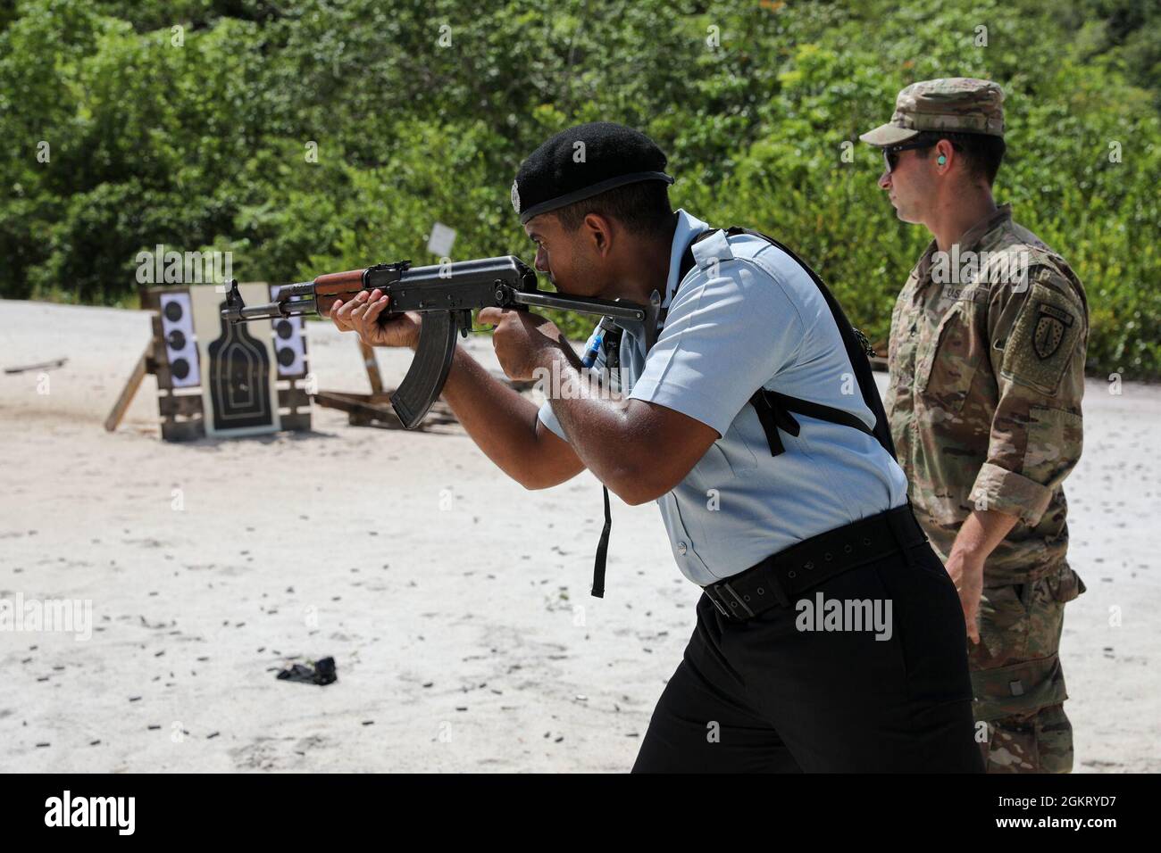 A U.S. Army Soldier with Florida Army National Guard’s (FLARNG) 2nd Battalion, 54th Security Force Assistance Brigade (SFAB) advises a member of the Guyana Police Force on the firing line during Tradewinds 2021, Camp Stephenson, Co-operative Republic of Guyana, June 24. FLARNG SFAB joined other reserve and active duty components as advisors to international forces throughout Tradewinds. Local Police Force representatives engaged in marksmanship training as part of the exercises interoperability development. Tradewinds 2021 is a U.S. Southern Command sponsored Caribbean security-focused exercis Stock Photo