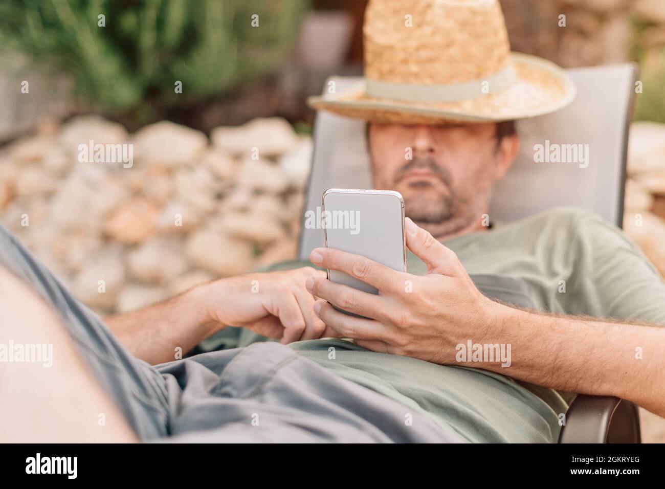 Freelancer and digital nomad working on smartphone during summer vacation holiday on apartment terrace in morning Stock Photo