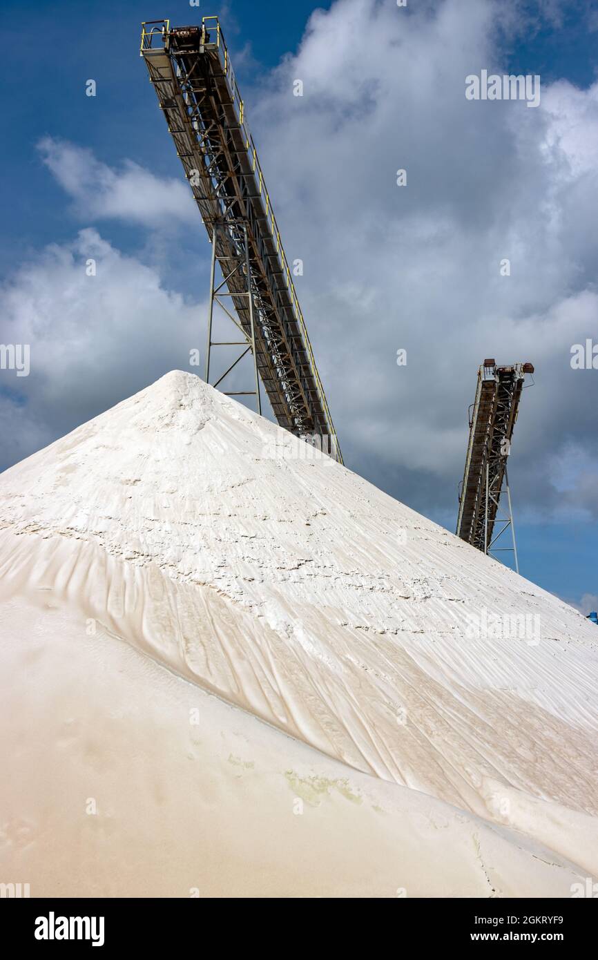 The group of the conveyor belts over a pile of the white sand Stock Photo