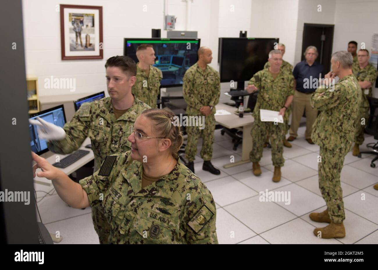 210624-N-XX139-0026 PENSACOLA, Fla. (June 24, 2021) Rear Adm. James Butler, (center with paper) commander, Naval Information Force Reserve (CNIFR) along with CNIFR’s Command Master Chief Kristie Barbier (front left), participate in a Multipurpose Reconfigurable Training System 3D® (MRTS 3D®) technology training device demonstration and discussion with staff at the Center for Information Warfare Training and Information Warfare Training Command (IWTC) Corry Station. The two visited for a familiarization brief and tour of CIWT and IWTC Corry Station to review information warfare training initiat Stock Photo