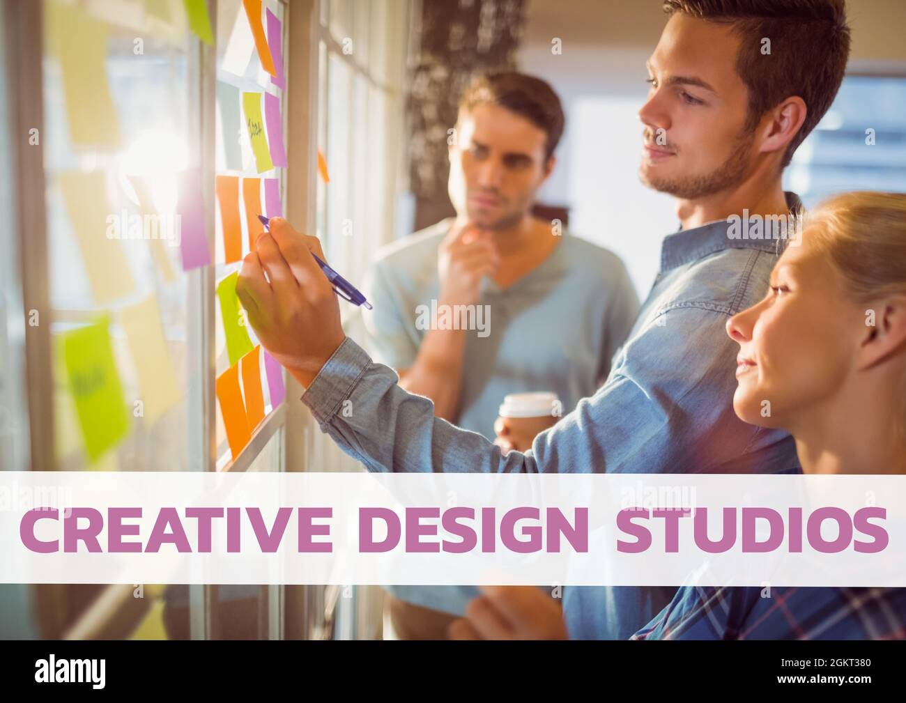 Creative design studios text banner against office colleagues writing on memo notes at office Stock Photo