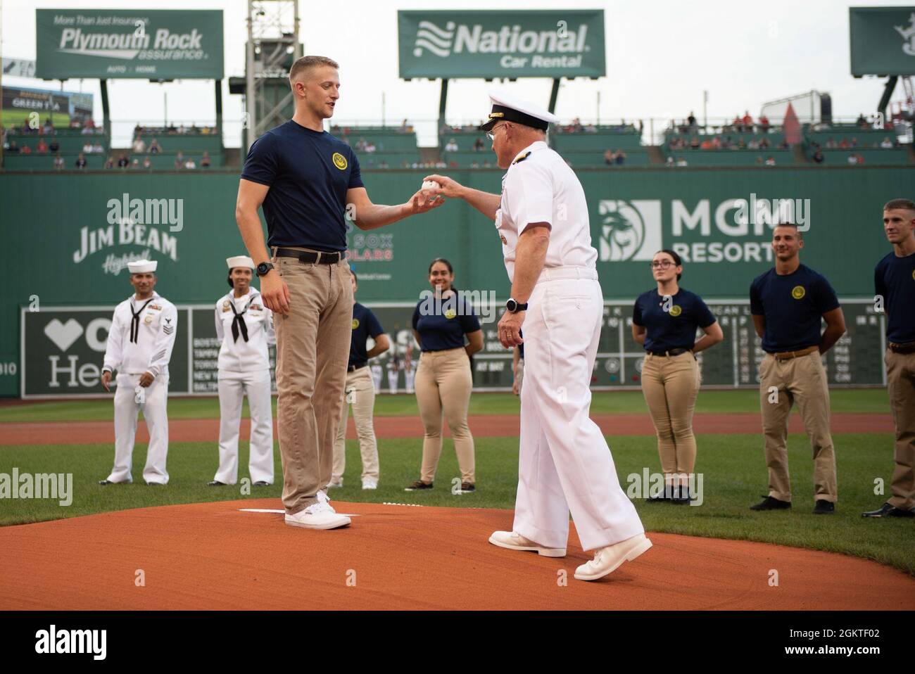 210629-N-BB269-1242 (June 29, 2021) Chief of Naval Operations Adm. Mike Gilday hands the first pitch to a newly-enlisted Navy Sailor to throw at a Red Sox baseball game at Fenway Park, Boston. Prior to the game, CNO administered the oath of enlistment to future U.S. Navy Sailors, Strike Fighter Squadron 213 (VFA-213) the Blacklions conducted a fly over, a Navy Band D.C. vocalist sang the national anthem, and the USS Constitution color guard paraded the colors in front of the audience. Stock Photo