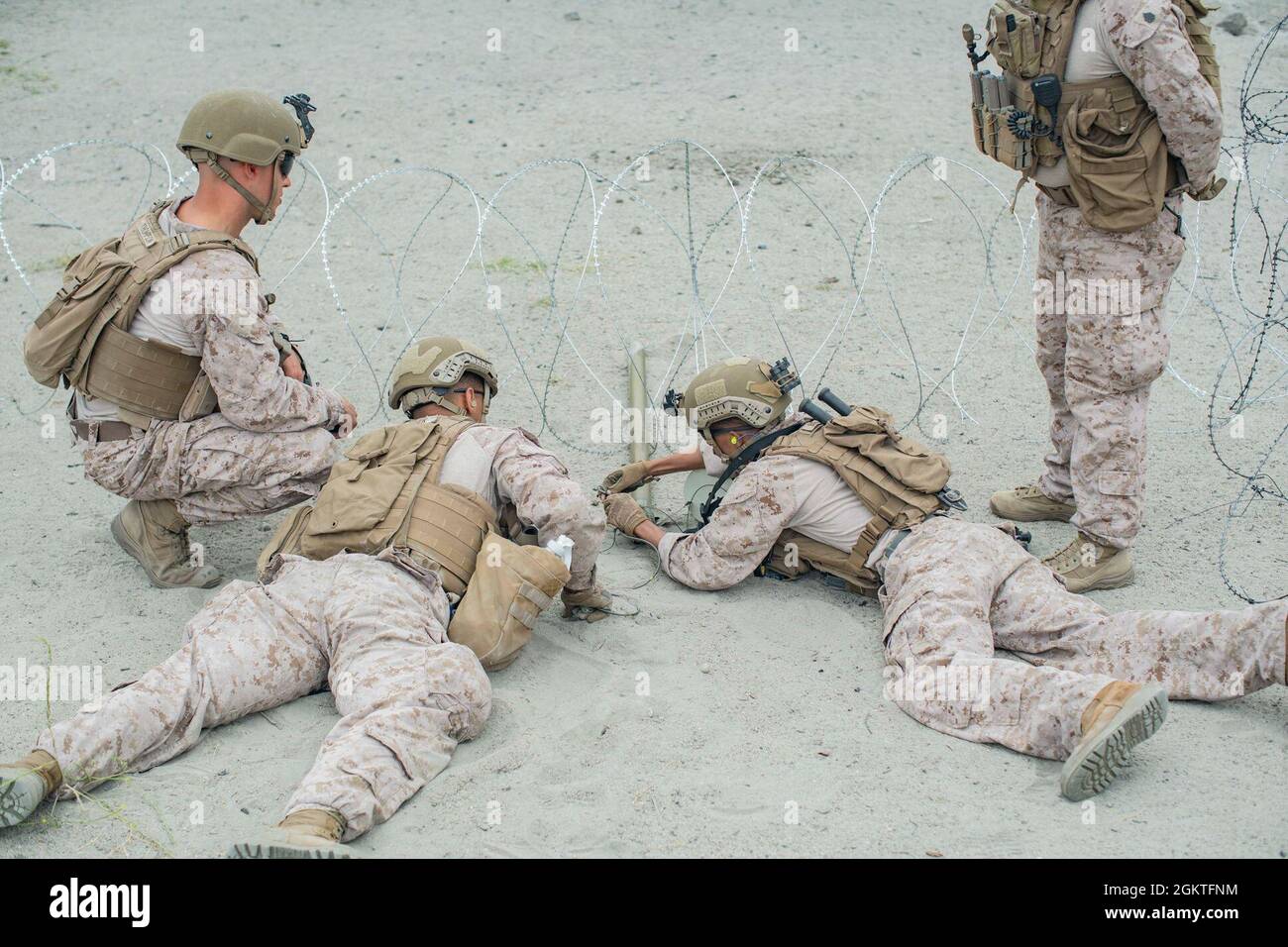 U.S. Marines with Combat Engineer Platoon, Headquarters and Service Company, Battalion Landing Team 1/1, 11th Marine Expeditionary Unit, prepare a bangalore torpedo to breach an obstacle during a breaching range at Marine Corps Base Camp Pendleton, California, June 29, 2021. The Marines conducted various types of mechanical and explosive breaching to sustain operational readiness for an upcoming deployment with the 11th MEU. Stock Photo