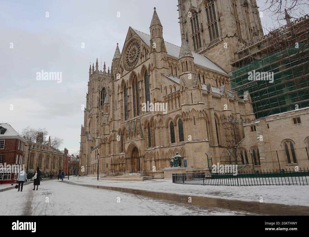 People walk past York Minster covered in snow, York, UK Stock Photo