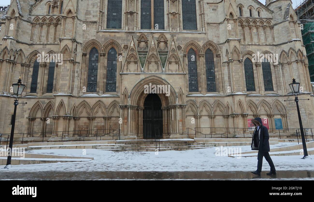 A person walks past York Minster covered in snow, York, UK Stock Photo